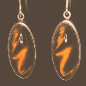 Elegant Tiger's Eye Earrings Discover the beauty of these elegant yellow tiger's eye earrings, featuring a stunning oval design that captures the light beautifully. The rich amber and black combination is complemented by a delicate silver setting. These earrings a perfect accessory for any occasion, from casual ro formal outings.